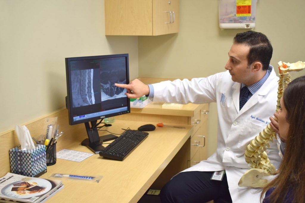 Dr. Melikian showing a patient their spine results